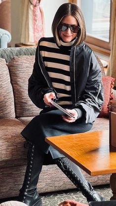 a woman sitting on top of a couch next to a wooden table