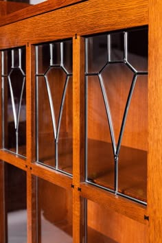 a wooden book case with glass doors on the front and side panels inlayed to each other