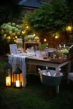 an outdoor dinner table with candles and lights