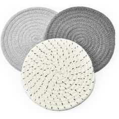 three round rugs in various colors and sizes on a white background with black dots