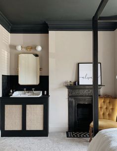 a bedroom with a bed, chair and fireplace in it's corner area next to a mirror on the wall