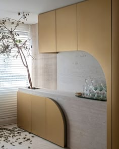 a kitchen with a tree in the middle of it and lots of bottles on the counter