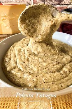 a white bowl filled with hummus and cheese