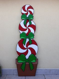 a large red and white peppermink candy cane decoration on the side of a building