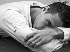 black and white photograph of a man with his head on his hands, resting his chin on his chest