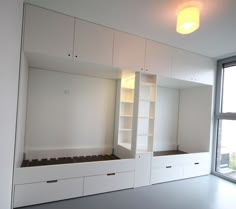 an empty room with built in bookshelves and cabinets