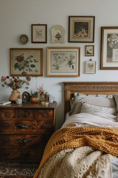 a bed sitting in a bedroom next to a dresser with pictures on the wall above it