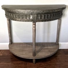 an old wooden table with metal accents on it's sides and a wood floor