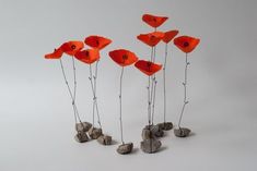 four red flowers are placed in the shape of rocks and pebbles on a white background