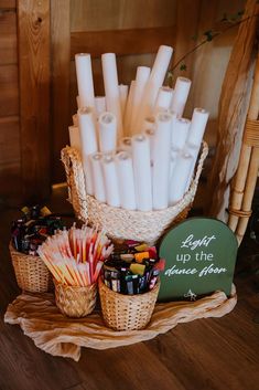 a basket filled with lots of white candles next to other small baskets full of candy