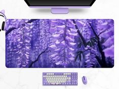 a computer mouse pad with purple flowers on the front and back side, along with a keyboard