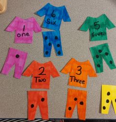 some paper cut out to look like clothes with numbers on them and the words two, three, five