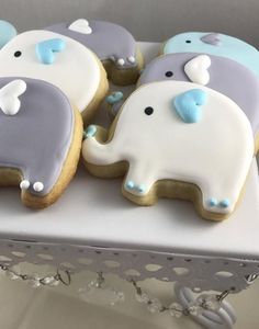 decorated cookies in the shape of elephants sitting on a table with white and blue icing