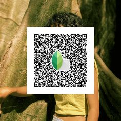 a person standing next to a tree with a qr code on it