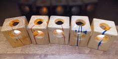 four wooden candles are lined up on a table