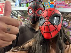 a person wearing a spider man mask gives the thumbs up sign in front of him