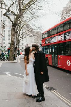 Bride and groom kissing by London red telephone booth by river Thames. London Red, Decker Bus