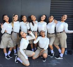 a group of women in white shirts and khaki pants posing for a photo