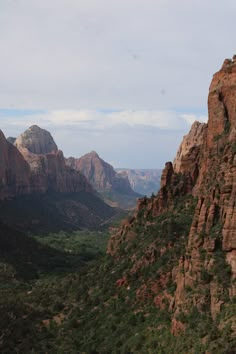 the mountains are surrounded by green trees and rocks