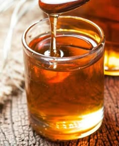 sugar free maple syrup is being poured into a glass jar