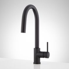 a black faucet on a white countertop with no one in the photo