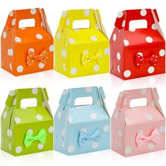 four different colored boxes with bows and polka dots on the sides, one for each