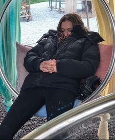 a woman is sitting in a circular chair