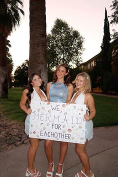 three girls holding a sign that says we mermaid for each other