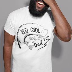 The pin shows a man wearing a white T-shirt with a design of a rod catching a fish and the text 'REEL COOL DAD.' Reel Cool Dad, Disney Couple T-shirt, Christmas Typography, Typography T Shirt, Happy Birthday Dad, Father's Day T Shirts, 50th Birthday Gifts, Typography Tshirt, Dad Birthday Gift