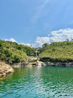 a body of water surrounded by lush green hills