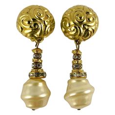 YVES SAINT LAURENT vintage gold toned dangling earrings (clip-on) featuring an arabesque design domed top and a large baroque faux pearl drop embellished with clear crystal rondelles. Embossed YSL Made in France. Indicative measurements : height approx. 6.3 cm (2.48 inches) / max diameter approx. 2.3 cm (0.91 inch). Comes with a YVES SAINT LAURENT box (used vintage condition). NOTES - This is a preloved vintage item, therefore it might have imperfections. - Colors may differ slightly from actual Ysl Vintage, Mid Century Earrings, Saint Laurent Vintage, Arabesque Design, French Fashion Designers, Earrings Clip, Dangling Earrings, Vintage Costume Jewelry, Arabesque