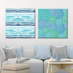 two paintings on the wall above a couch in a room with blue and white decor