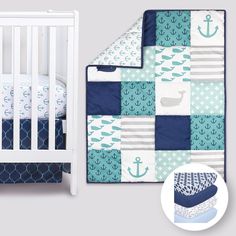 a baby crib bedding set with an anchor and whale quilt on the bottom