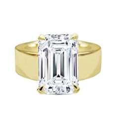 a yellow gold ring with an emerald cut diamond in the center and two clawed shoulders