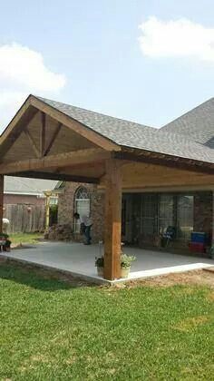 a covered patio in the middle of a yard