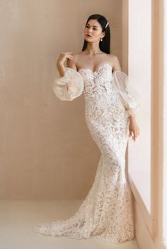 a woman in a wedding dress leaning against a wall