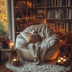 a living room filled with lots of books and furniture next to a window covered in lights