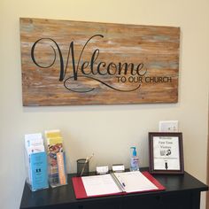 a welcome sign is on the wall above a desk