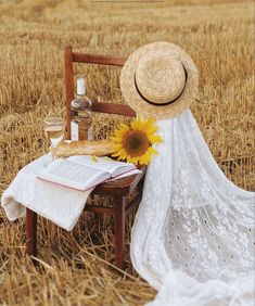 a sunflower sitting on top of a wooden chair next to a book and bottle