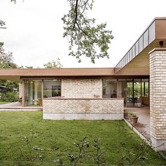 a brick house sitting on top of a lush green field