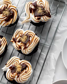 four cupcakes with chocolate and white frosting on a cooling rack