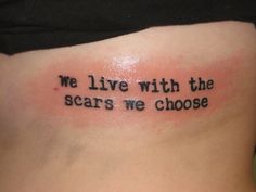 a woman with a tattoo saying me live with the scars we choose on her back