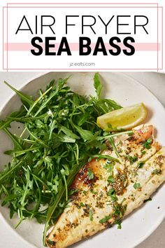 an air fryer sea bass is served with fresh greens and lemon wedges on the side