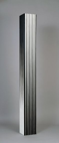 a tall black and white metal object against a gray background