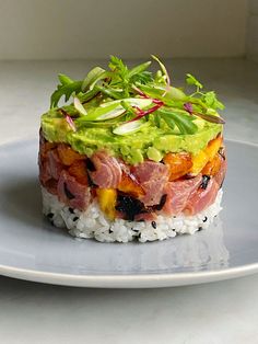 a white plate topped with rice covered in meat and veggies on top of it