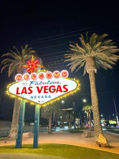 the welcome to fabulous las vegas sign lit up at night with palm trees and buildings in the background