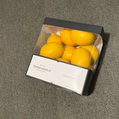 a box filled with oranges sitting on top of a carpet