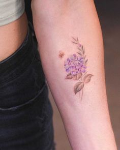 a woman's arm with a flower tattoo on it