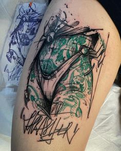 a tattoo on the thigh of a woman's leg that has been drawn with black and green ink