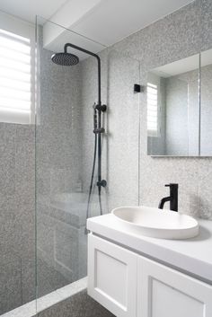 a white sink sitting under a bathroom mirror next to a walk in shower and toilet